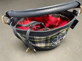 a black purse with a red and yellow plaid lining