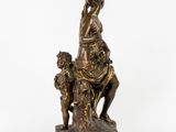 a bronze statue of a woman sitting on a rock with two children