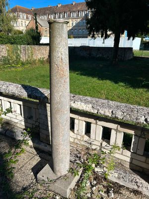 a stone column sitting in the middle of a park