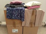 a pile of clothes sitting on top of a cardboard box