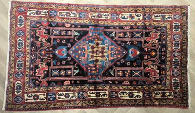 un tapis posé sur un parquet, orné d'un motif bleu et rouge