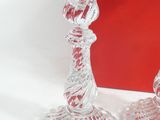 two glass candlesticks sitting next to a red box