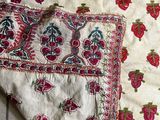 a piece of cloth with a design on it sitting on a tile floor