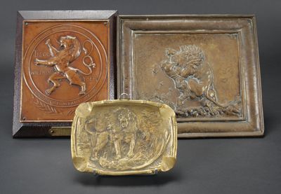 trois plaques en bronze représentant des lions et un lion sur fond noir