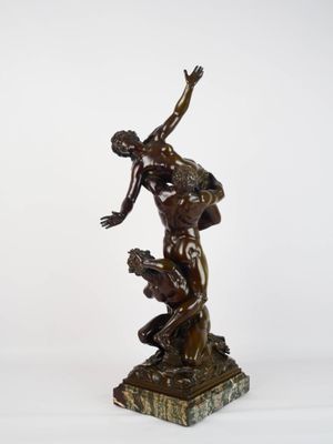 une image représentant une statue en bronze d'un homme assis sur un rocher