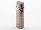 un briquet argenté posé sur une surface blanche