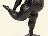 statue of a man holding a ball on a base on a white background