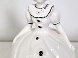 a white ceramic figurine of a woman in a dress