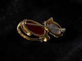a close up of a pair of brooches on a black cloth