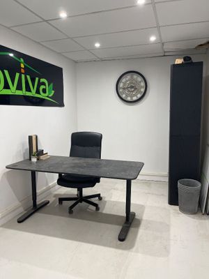 un bureau avec une chaise et une horloge accrochée au mur
