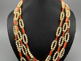 un collier de perles orange et blanches sur un mannequin noir