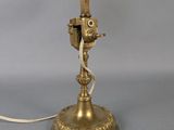 an antique brass desk lamp with a brass arm and a white cord