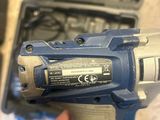 someone is holding a cordless drill in their hand with a tool in the background