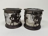 two glass vases with horses on them on a table