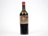 une vieille bouteille de vin posée sur une surface blanche