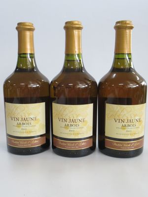 trois bouteilles de vin sont alignées sur une surface blanche