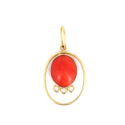 un gros plan d'un pendentif plaqué or orné d'une pierre rouge