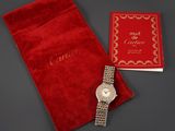 a lady ' s cartier watch with a red velvet pouch