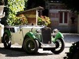 une voiture de collection verte et blanche garée devant un immeuble