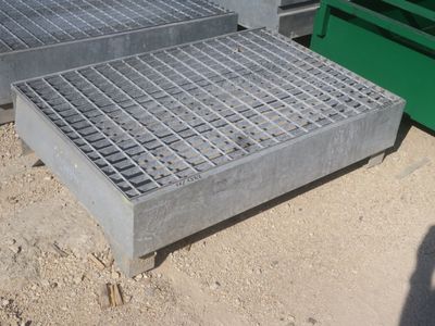 plusieurs grilles en acier sont empilées les unes sur les autres dans la terre
