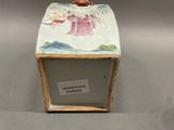 a small box with a painting on it sitting on a table