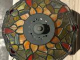 a close up of a stained glass lamp on a wall