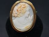 gros plan d'une bague en or avec un camée représentant une femme