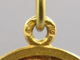 gros plan d'une pièce d'or avec un visage dessus