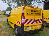 two yellow vans parked next to each other in a field