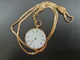 une chaîne en or sur laquelle est accrochée une montre