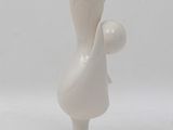 a small white sculpture of a woman holding a ball