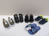 Plusieurs paires de chaussures d'enfants sont alignées sur une table