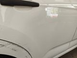 a close up of a white car with scratches on it