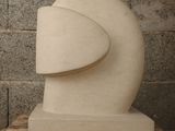 a white sculpture on a table in front of a brick wall