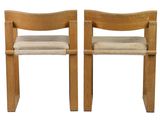 two wooden chairs with beige cushions on them against a white background