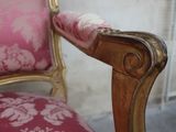 a close up of a pink chair with a gold frame
