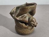 un petit vase dans lequel se trouve un petit animal