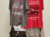 two shirts hanging on a rack in front of a white wall