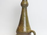 a green vase that is sitting on a white surface