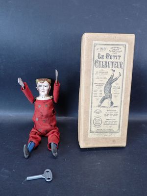 une petite poupée assise à côté d'une boîte