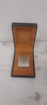 a small box with a silver coin in it on a marble surface
