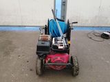 a small lawn mower with a hose attached to it