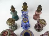 many different colored vases sitting on a white surface