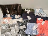 beaucoup de vêtements et un sac à main posés sur une table