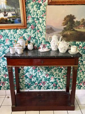 une petite table sur laquelle sont posées des tasses à thé et des théières