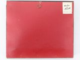 an old red suitcase with a label on it sitting on a white surface