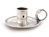 a silver plate with a silver candle holder on it