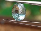 un gros plan d'un diamant bleu tenu par une paire de pinces