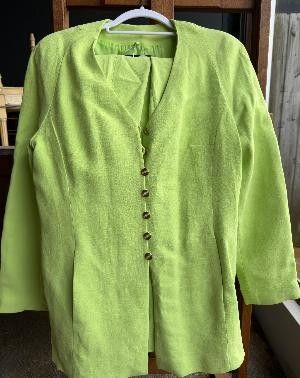 une veste vert citron suspendue à un cintre devant une fenêtre
