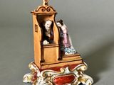 a figurine of a man and a woman sitting on a bench